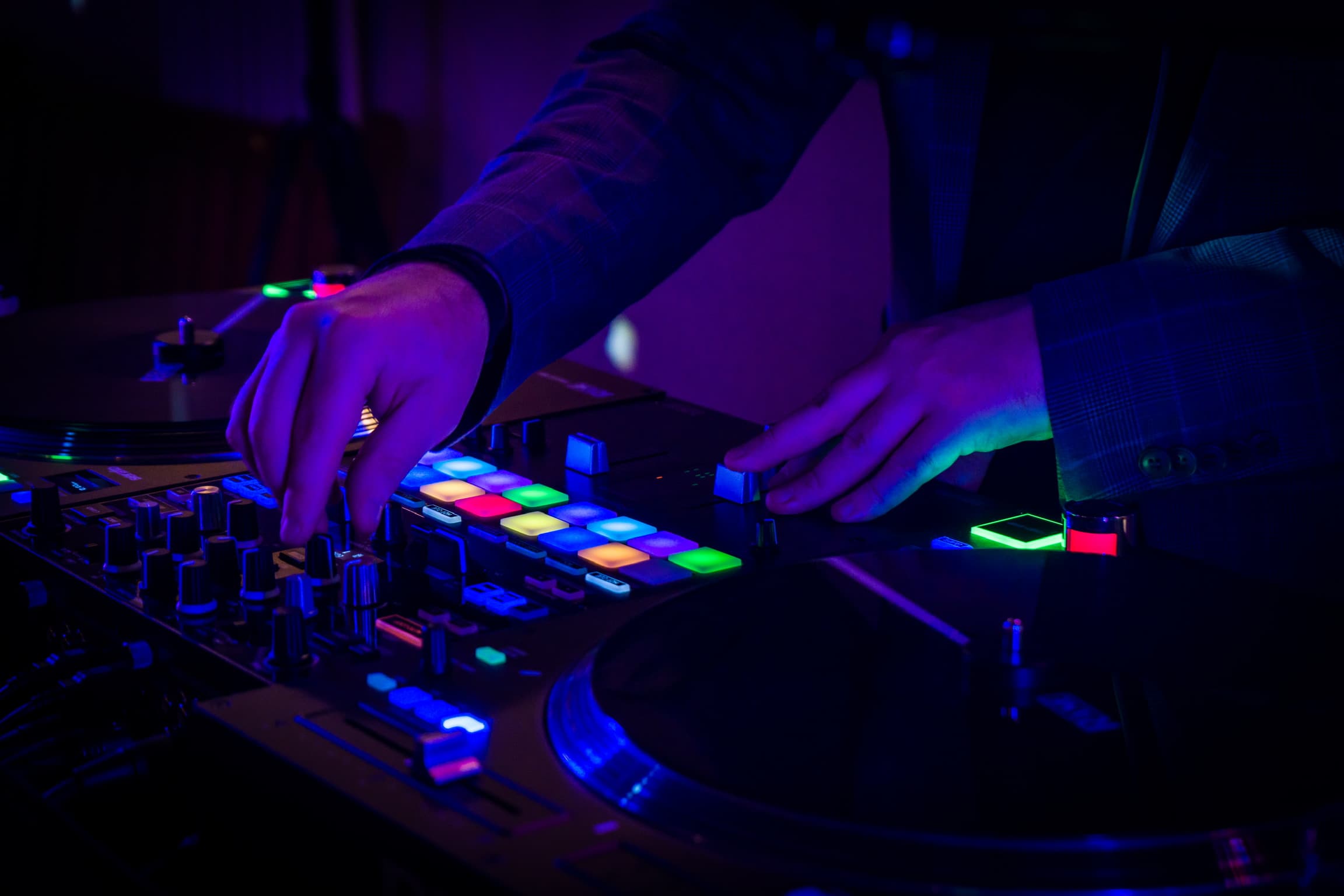 DJ-Pult mit leuchtenden Pads in violettem Partylicht