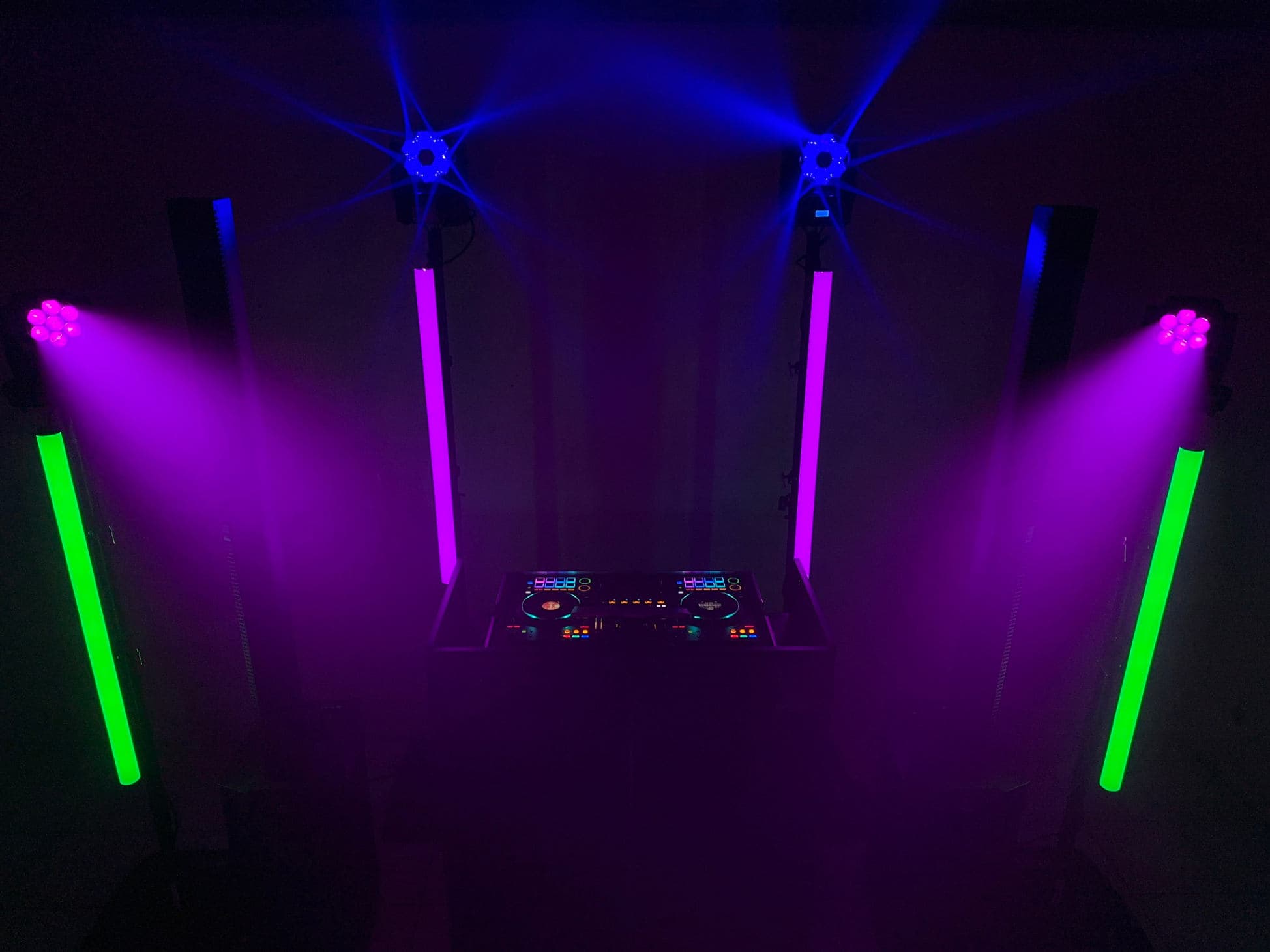 DJ-Pult mit LED-Tubes und Moving Heads in violettem Licht